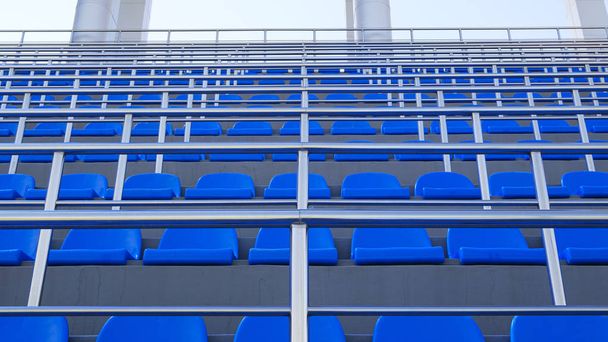 Μπλε πλαστικά καθίσματα. Δωρεάν καθίσματα στην αρένα. Κενές καρέκλες καθισμάτων για τους οπαδούς του ποδοσφαίρου. - Φωτογραφία, εικόνα