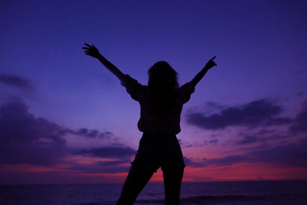 Черный женский силуэт на фиолетовом небе заката с облаками на заднем плане, Гавайи
. - Фото, изображение