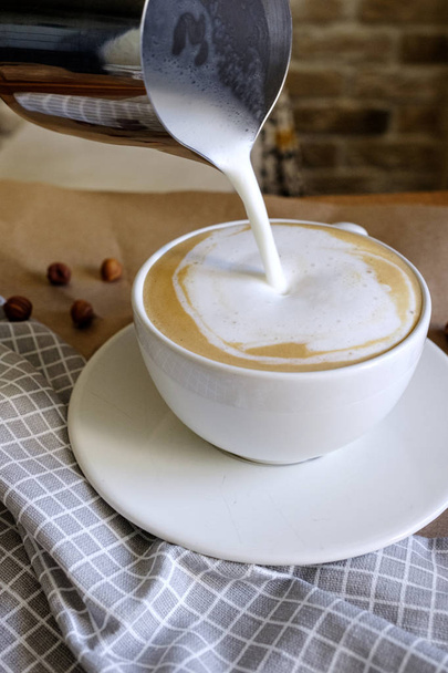 Image rapprochée de mains masculines versant du lait et préparant cappuccino frais, cafetière et concept de préparation, café du matin - Photo, image