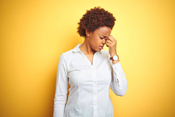 Africká americká podnikatelka na izolovaném žlutém pozadí unavené tření a oči cítí únavu a bolest hlavy. Koncepce stresu a frustrace. - Fotografie, Obrázek