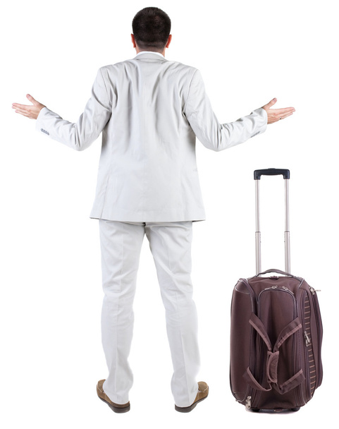 Back view of shocked business man with suitcase looking up. - Foto, afbeelding
