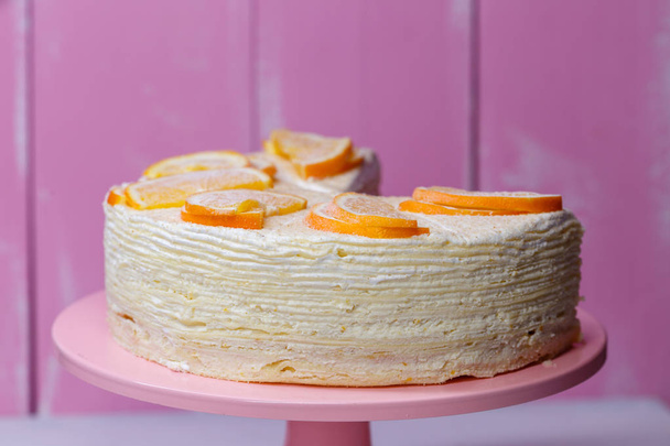 homemade pancake creamy cake with white delicate cream and oranges on a pink background - Foto, immagini