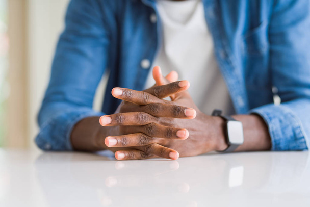 Κοντά σε σταυρωτά χέρια Αφρικανός άνθρωπος πάνω από το τραπέζι - Φωτογραφία, εικόνα