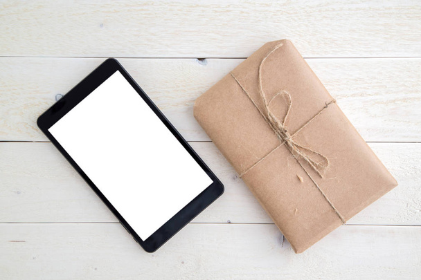 parcel,gift Packed in eco-friendly paper and tablet on light woo - Valokuva, kuva