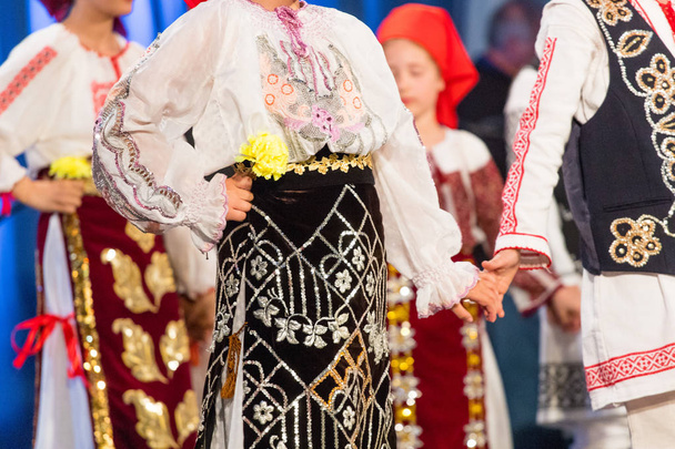 A fiatal román táncosok kezében egy néptánc a népi jelmezben. Romániai folklór - Fotó, kép