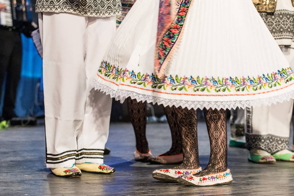 Bliska nogi młodych rumuńskich tancerzy wykonują taniec ludowy w tradycyjnym stroju folklorystycznego. Folklor Rumunii - Zdjęcie, obraz