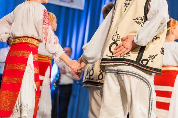 Giovane ballerino rumeno si tiene per mano sulla schiena mentre esegue una danza popolare in costume folcloristico tradizionale. Folclore di Romania
 - Foto, immagini