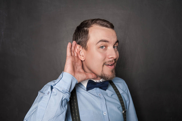 Yakışıklı komik adam tahtaüzerinde kulak misafiri  - Fotoğraf, Görsel