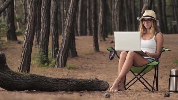 Souriante fille travaillant sur ordinateur portable à l'extérieur en vacances d'été
. - Séquence, vidéo