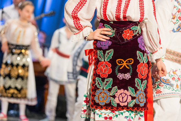 Gros plan s de jeunes danseurs roumains effectuer une danse folklorique en costume folklorique traditionnel. Folklore de Roumanie
 - Photo, image