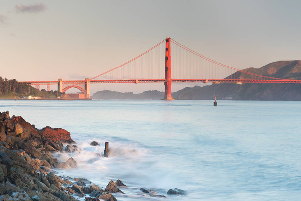 Classic panoramic view of famous Golden Gate Bridge seen from San Francisco harbour in beautiful morning light o with blue sky in summer or spring, San Francisco, California, USA - Photo, Image