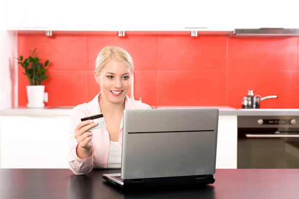 Woman in kitchen with laptop and credit card - Fotoğraf, Görsel