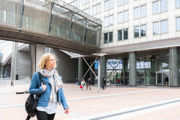 Business woman in casual clothes walking down the street in front of a business center - Foto, Bild