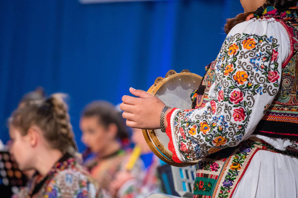 Κλείστε τα χέρια της νεαρής ρουμανικής κοπέλας με παραδοσιακό Λαογραφικό κοστούμι. Λαογραφία της Ρουμανίας - Φωτογραφία, εικόνα
