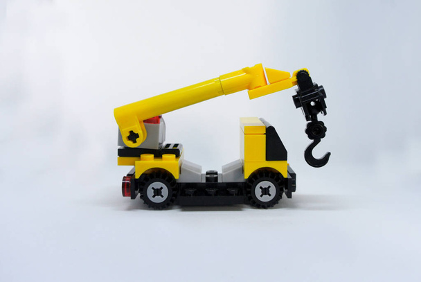 Selective focused miniature of mobile crane machine made from plastic block and isolated on white background.  - Photo, Image