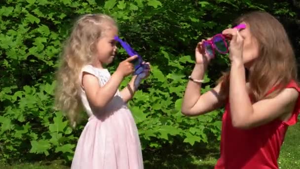 Familienmädchen Mutter und Tochter setzen riesige Sonnenbrille auf und zeigen Finger hoch - Filmmaterial, Video