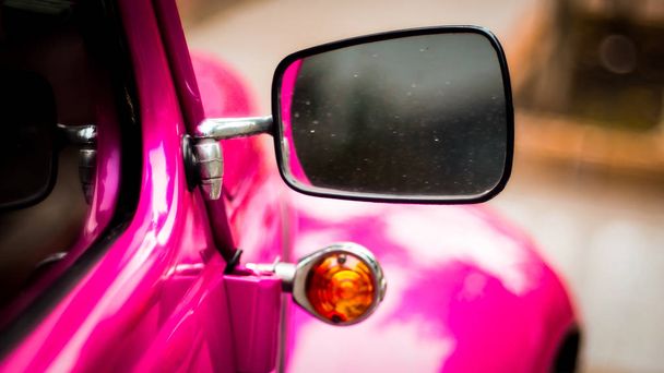 Side mirror and window of apink vintage car - Foto, Bild