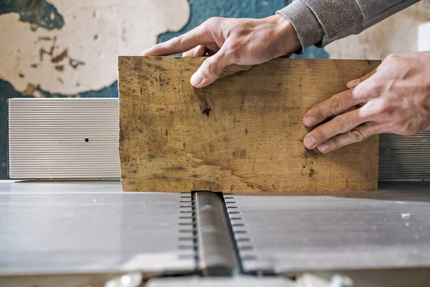 Człowiek robi drewniane części do mebli na maszynie grubość Strugarka. - Zdjęcie, obraz