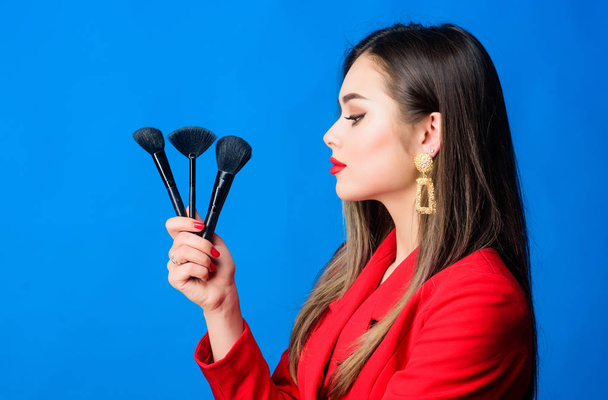 Looking good and feeling confident. Professional makeup supplies shop. Makeup courses. Gorgeous lady make up red lips. Attractive woman applying makeup brush. Perfect skin tone. Makeup artist concept - Photo, image