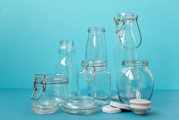 Glass jars standing on blue background. Eco friendly, reuse or zero waste concept. - Zdjęcie, obraz