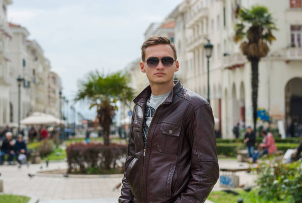 Young handsome man in sunglasses, tourist, on the pedestrian Ari - Foto, imagen