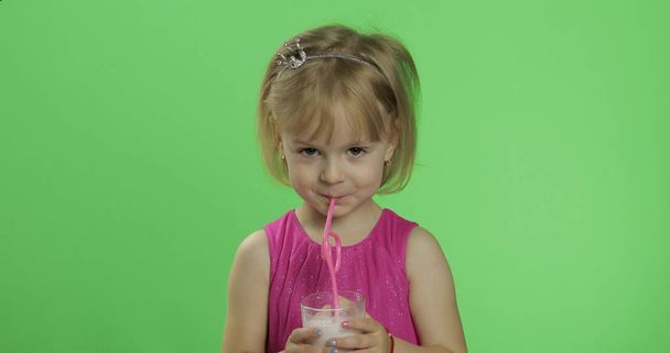 Feliz niño de cuatro años en vestido rosa bebe cóctel batido. Clave de croma
 - Foto, Imagen