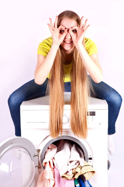 Beautiful girl sitting on top of the washing machine. Washing machine advertising - Foto, afbeelding