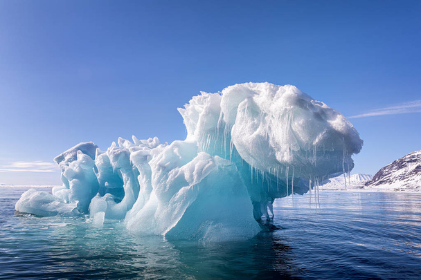 Kék jéghegy, amelyet akkor alakítottak ki, amikor egy gleccserborjú lebegett a Svalbard sarkvidéki vizein, egy norvég szigetcsoport Norvégia és az Északi-sark között. - Fotó, kép