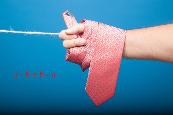 Krawatte mit klassischem Knoten, an einem Seil aufgehängt und an hölzernen Wäscheklammern befestigt, um Kleidung aufzuhängen - Foto, Bild