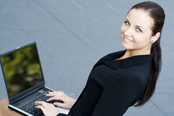 Businesswoman using laptop outdoors - Valokuva, kuva