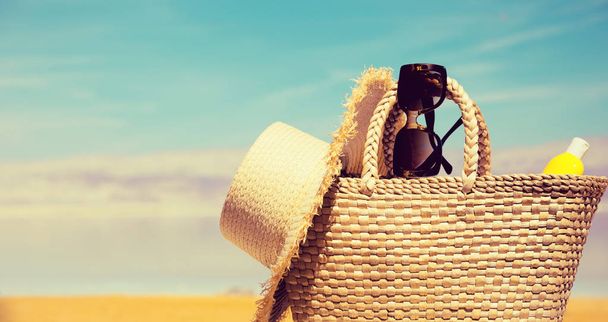 Sac à paille, lunettes de soleil, une bouteille de crème solaire et un chapeau wi
 - Photo, image