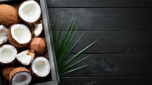 Coconut in a wooden box. Tropical Fruits. Nut. Top view. Free space for your text. - Foto, Bild