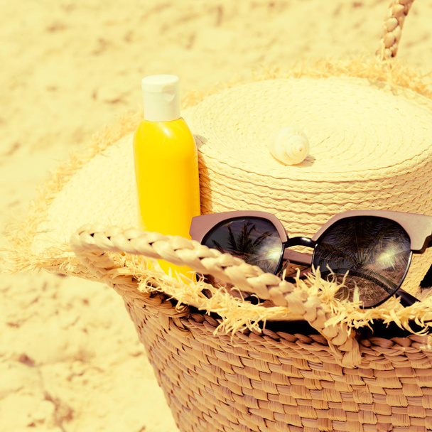 Соломенная шляпа, раковина, бутылка крема от загара, солнцезащитные очки и s
 - Фото, изображение