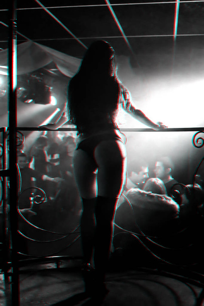 silhouette of a girl go-go dancer on stage in a nightclub - Foto, Imagen