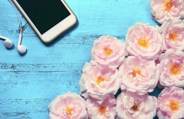 Beautiful summer background with fresh roses, smartphone and whi - Zdjęcie, obraz