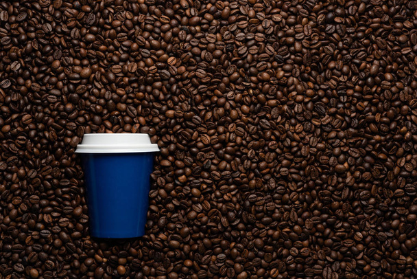 Blue disposable cup to go, on the background of coffee beans with empty space for text. - Φωτογραφία, εικόνα