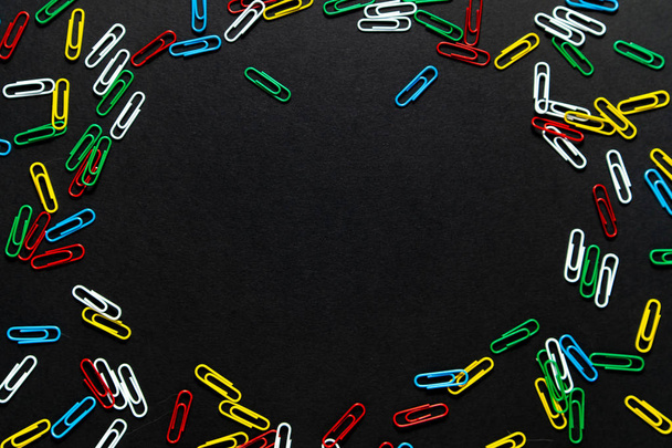 colored paper clips on a black background - 写真・画像