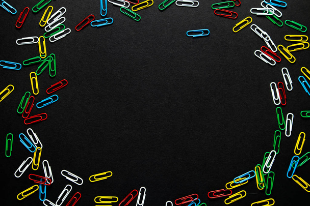 colored paper clips on a black background - Valokuva, kuva