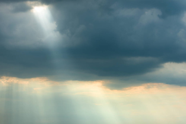 Dramaattinen myrskytaivas tummilla pilvillä ja kirkkailla auringonsäteillä
 - Valokuva, kuva