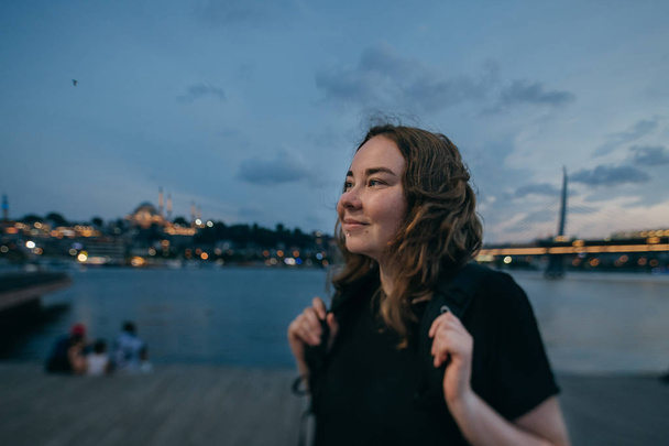 Het meisje bij zonsondergang aan de waterkant op de achtergrond van de CI - Foto, afbeelding