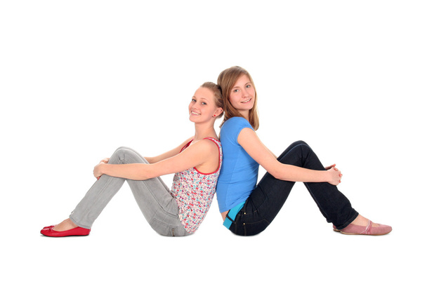 Two young women sitting back to back - Photo, Image