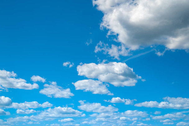 Wolken in de blauwe lucht. Blauwe lucht en veel wolken van verschillende groottes in winderig weer in de zomer.  - Foto, afbeelding