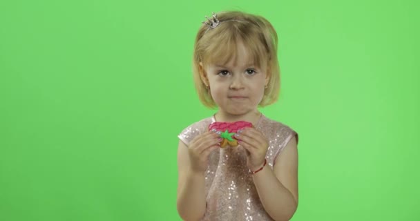 Chica en vestido brillante comienza a comer galletas en forma de fresas
 - Metraje, vídeo