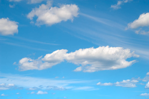暖かい青空に白い雲。夏の風の強い天候の青空と大小の雲.  - 写真・画像