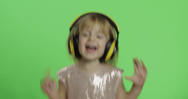 Girl in glossy dress and headphone listening to music and dancing. Chroma Key - Footage, Video
