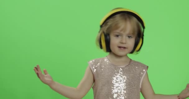 Chica en vestido brillante y auriculares escuchando música y bailando. Clave de croma
 - Imágenes, Vídeo