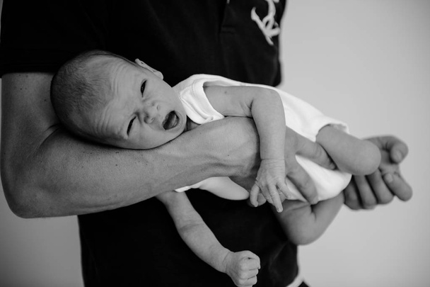 emotionaalinen vastasyntynyt lapsi vanhemman käsissä
  - Valokuva, kuva