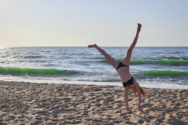 Güzel kadının Yoga asana Beach ufuk arka plan ile yapması. - Fotoğraf, Görsel