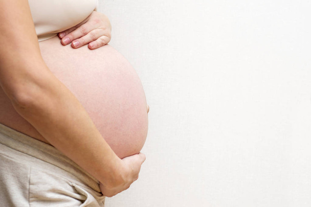Εικόνα της εγκύου γυναίκα που αγγίζει τη μεγάλη κοιλιά της. Μητρότητα, εγκυμοσύνη, άνθρωποι και προσδοκίες. Έγκυος γυναίκα περιμένει το μωρό - Φωτογραφία, εικόνα