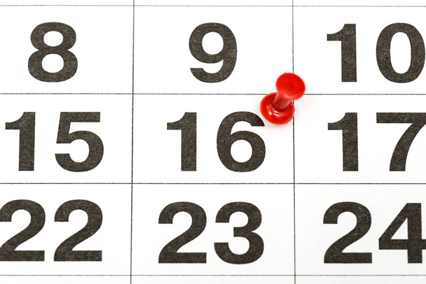 Pin sur la date numéro 16. Le seizième jour du mois est marqué par une miniature rouge. Broche sur le calendrier
 - Photo, image